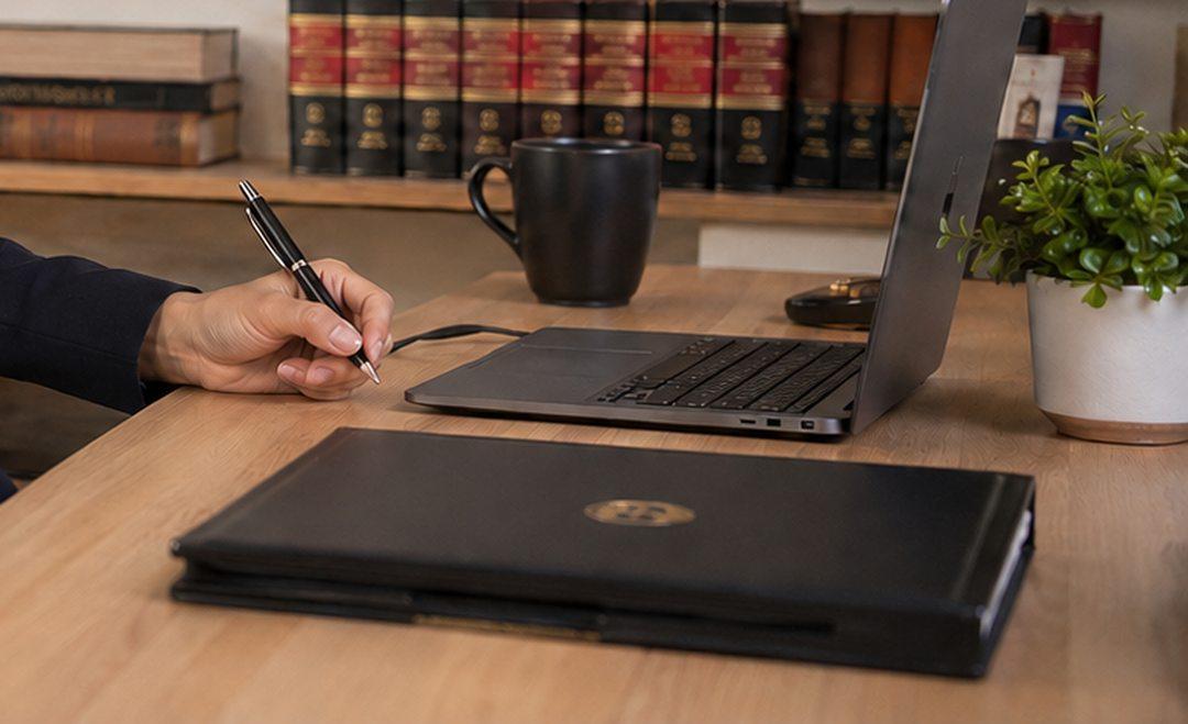 Escritorio de trabajo con expediente, laptop y pluma durante el análisis de un caso.